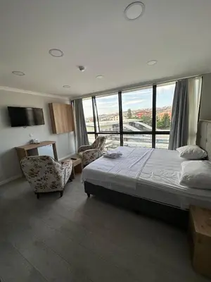 a bedroom with a bed and a chair and windows at The my hotel darica in Darıca