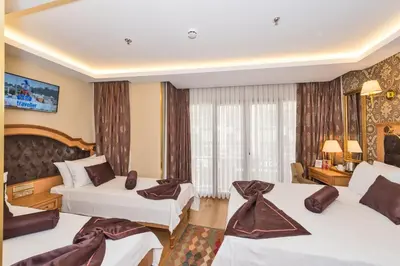 a hotel room with three beds and a window at Aprilis Gold Hotel - Special Category in Istanbul
