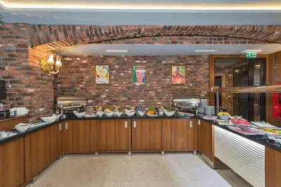 a kitchen with wooden cabinets and a brick wall at Aprilis Gold Hotel - Special Category in Istanbul