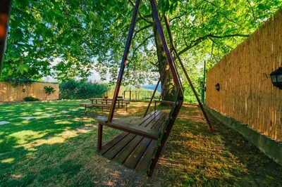a wooden swing under a tree in a park at Sepetçi Lakehouse Heated Pool in Kartepe
