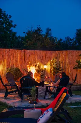 a group of people sitting around a fire in a backyard at Sepetçi Lakehouse Heated Pool in Kartepe