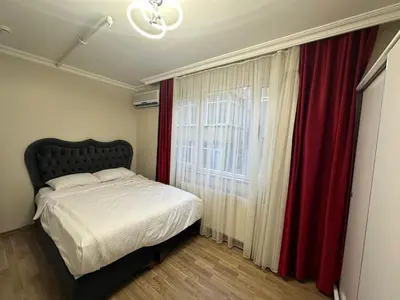 a bedroom with a bed and a window with red curtains at Apartment in Sisli Mado14 in Istanbul
