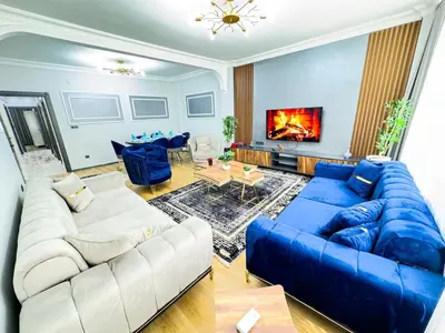 a living room with a blue couch and a fireplace at Dream Apartment in Sheshli 5 4 1 in Istanbul