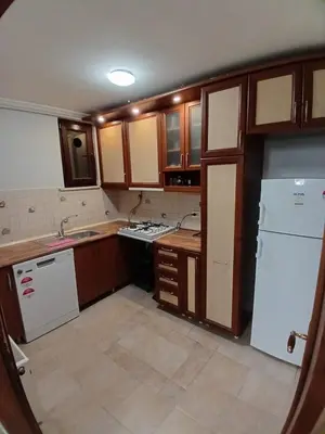 a kitchen with wooden cabinets and a white refrigerator at Luxurious apartment in Sisli area, three rooms and a living room in Istanbul