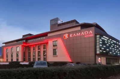 a building with a red neon sign in front of it at Ramada by Wyndham Gemli̇k in Gemlik
