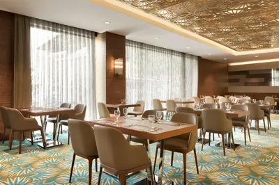 a restaurant with tables and chairs in a room at Ramada by Wyndham Gemli̇k in Gemlik