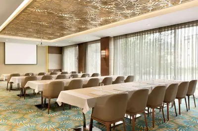 a conference room with rows of tables and chairs at Ramada by Wyndham Gemli̇k in Gemlik