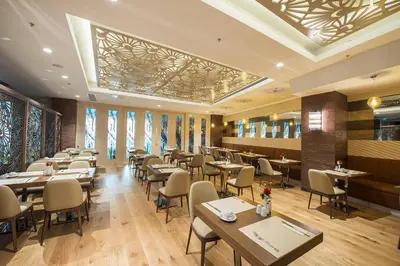a restaurant with tables and chairs and windows at Ramada by Wyndham Gemli̇k in Gemlik