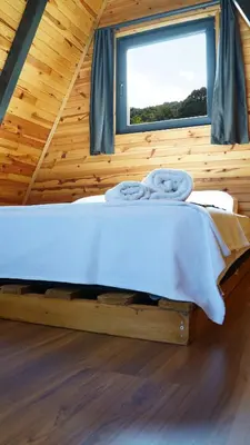 a bed in a wooden room with a window at Hilltop Bungalov Sapanca 1 in Sapanca
