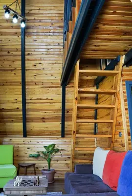 a living room with wooden walls and a staircase at Hilltop Bungalov Sapanca 1 in Sapanca