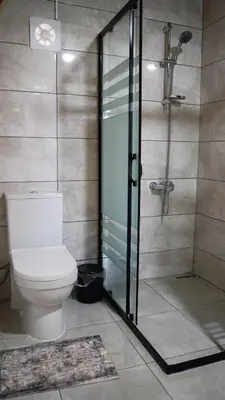 a bathroom with a toilet and a glass shower at Hilltop Bungalov Sapanca 1 in Sapanca