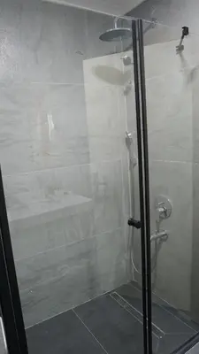 a shower with a glass door in a bathroom at Karadeniz Hotel Çorlu in Corlu