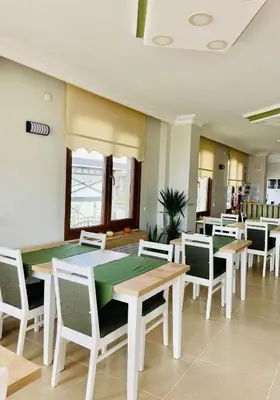 a dining room with a table and chairs at Ağva Manolyam Otel in Sile