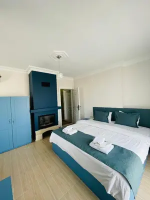a bedroom with a large bed and a fireplace at Ağva Manolyam Otel in Sile