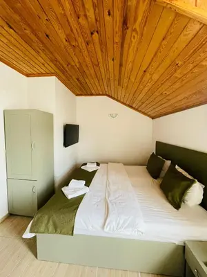 a bedroom with a large bed with a wooden ceiling at Ağva Manolyam Otel in Sile