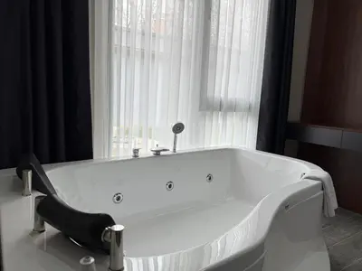 a white bath tub sitting in front of a window at Hilloria Tatil Köyü in Sapanca