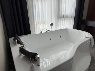 a white bath tub in a room with a window at Hilloria Tatil Köyü in Sapanca