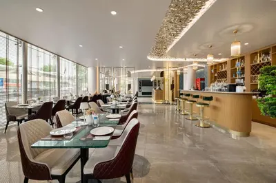 a restaurant with tables and chairs and a bar at Tryp by Wyndham Istanbul Beyoglu in Istanbul