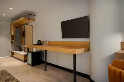 a room with a desk with a tv on a wall at Tryp by Wyndham Istanbul Beyoglu in Istanbul