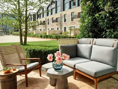 a couch and chairs on a patio in front of a building at Aliée Istanbul - A Paris Society Collection Hotel in Istanbul