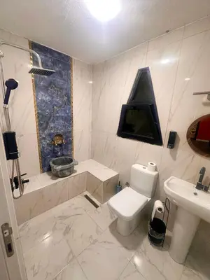 a white bathroom with a toilet and a sink at Bigados Otel & Bungalov in Silivri