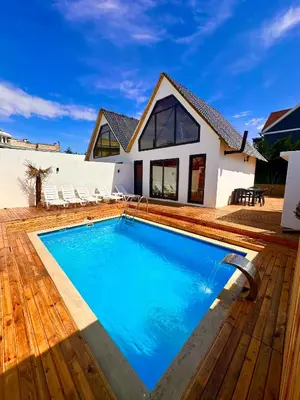 a swimming pool in front of a house at Bigados Otel & Bungalov in Silivri