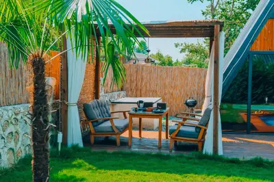 a patio with a table and chairs and a fence at Maya Sapanca Bungalow in Sapanca