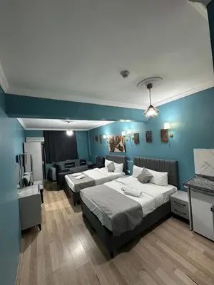 two beds in a room with blue walls at Ada Apart Otel in Istanbul