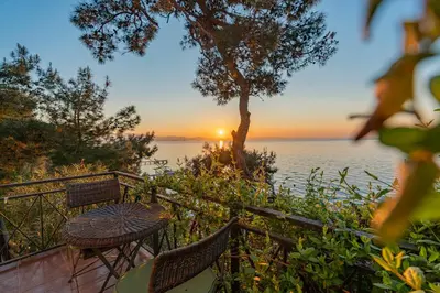 a table and chairs on a balcony with a view of the water at Palais Büyükada in Adalar