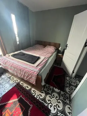 a small bedroom with a bed and a rug at Murat bey konağı in Istanbul