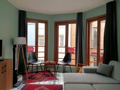 a living room with a couch and chairs and windows at Murat bey konağı in Istanbul