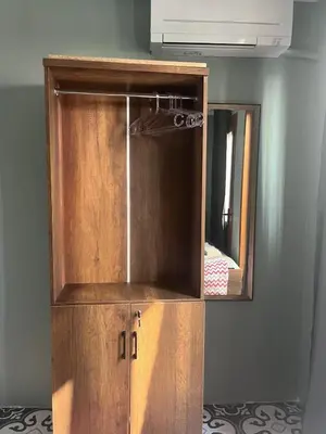 a wooden cabinet with a mirror in a room at Murat bey konağı in Istanbul