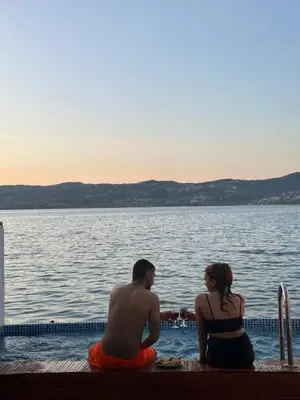 a man and a woman sitting next to a body of water at Flamingo Sapanca in Sapanca