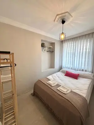 a bedroom with a large bed with a red pillow at Pink House - Central Location by Seashore, Fiber Internet in Istanbul