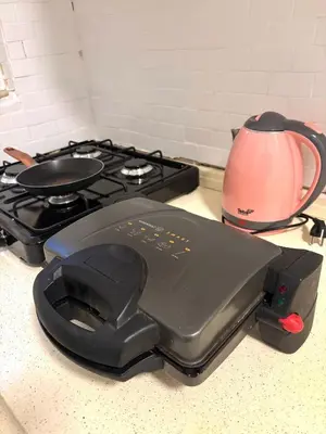 a black stove top with a pink tea pot next to it at Pink House - Central Location by Seashore, Fiber Internet in Istanbul