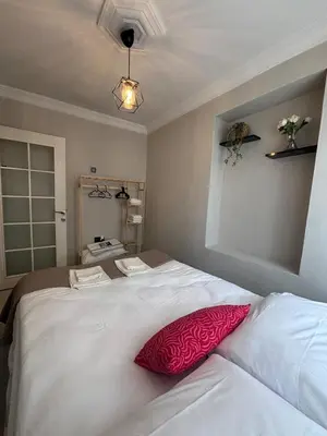 a bedroom with a large white bed with a red pillow at Pink House - Central Location by Seashore, Fiber Internet in Istanbul