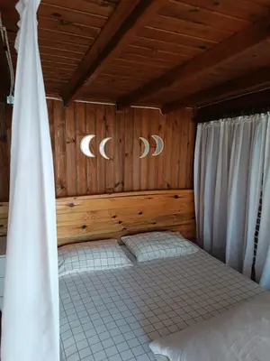 a bedroom with a bed with wooden walls and curtains at Flamingo aura in Sapanca