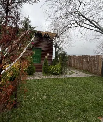 a log cabin in a yard with a fence at Flamingo aura in Sapanca