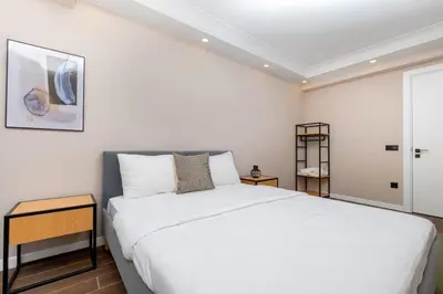 a white bedroom with a large bed and a table at Luxury Stay with Panoramic Bosphorus View in Istanbul