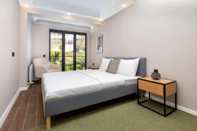 a bedroom with a bed and a chair and a window at Luxury Stay with Panoramic Bosphorus View in Istanbul