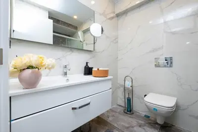 a white bathroom with a toilet and a sink at Luxury Stay with Panoramic Bosphorus View in Istanbul