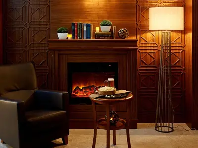 a living room with a fireplace and a chair and a table at Renata Boutique Hotel Sisli in Istanbul