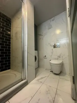 a white bathroom with a toilet and a shower at Gezgin Residence in Istanbul