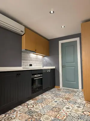 a kitchen with gray cabinets and a blue door at Gezgin Residence in Istanbul