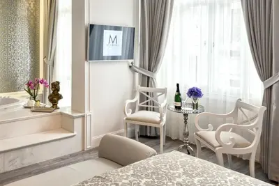 a bedroom with a bed and a table and chairs at Mirrors Hotel İstanbul Taksim City Center in Istanbul