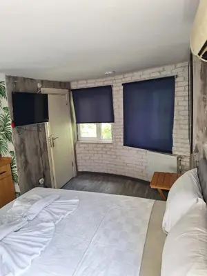 a bedroom with a large bed and two large windows at Hendec 7 Apartments Near Galataport in Istanbul
