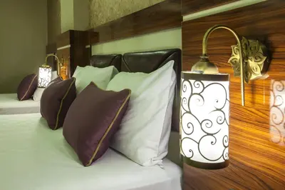 a bedroom with a bed with pillows and a lamp at Ruba Palace Thermal Hotel in Bursa