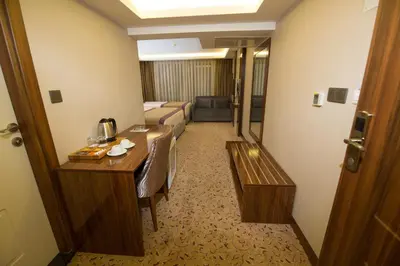 a hotel room with a living room with a table and a couch at Ruba Palace Thermal Hotel in Bursa