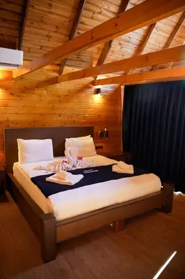 a bedroom with a bed in a wooden room at Navy Inn & Bungalows in Arnavutköy