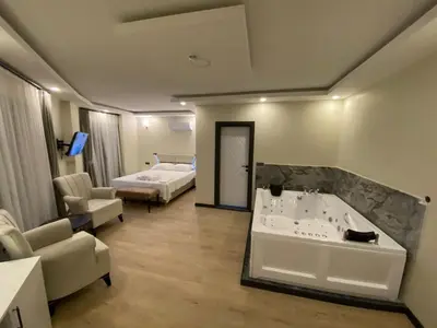 a hotel room with a bath tub and a bedroom at Ağva Capella Hideaway Hotel in Sile